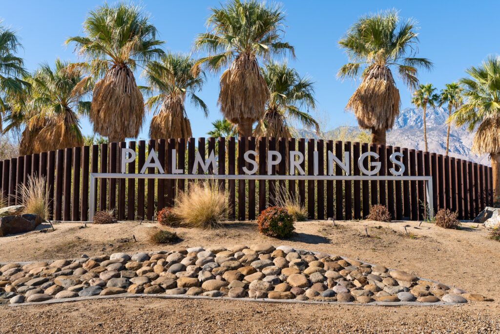 Palm Springs California sign with palm treas in the background